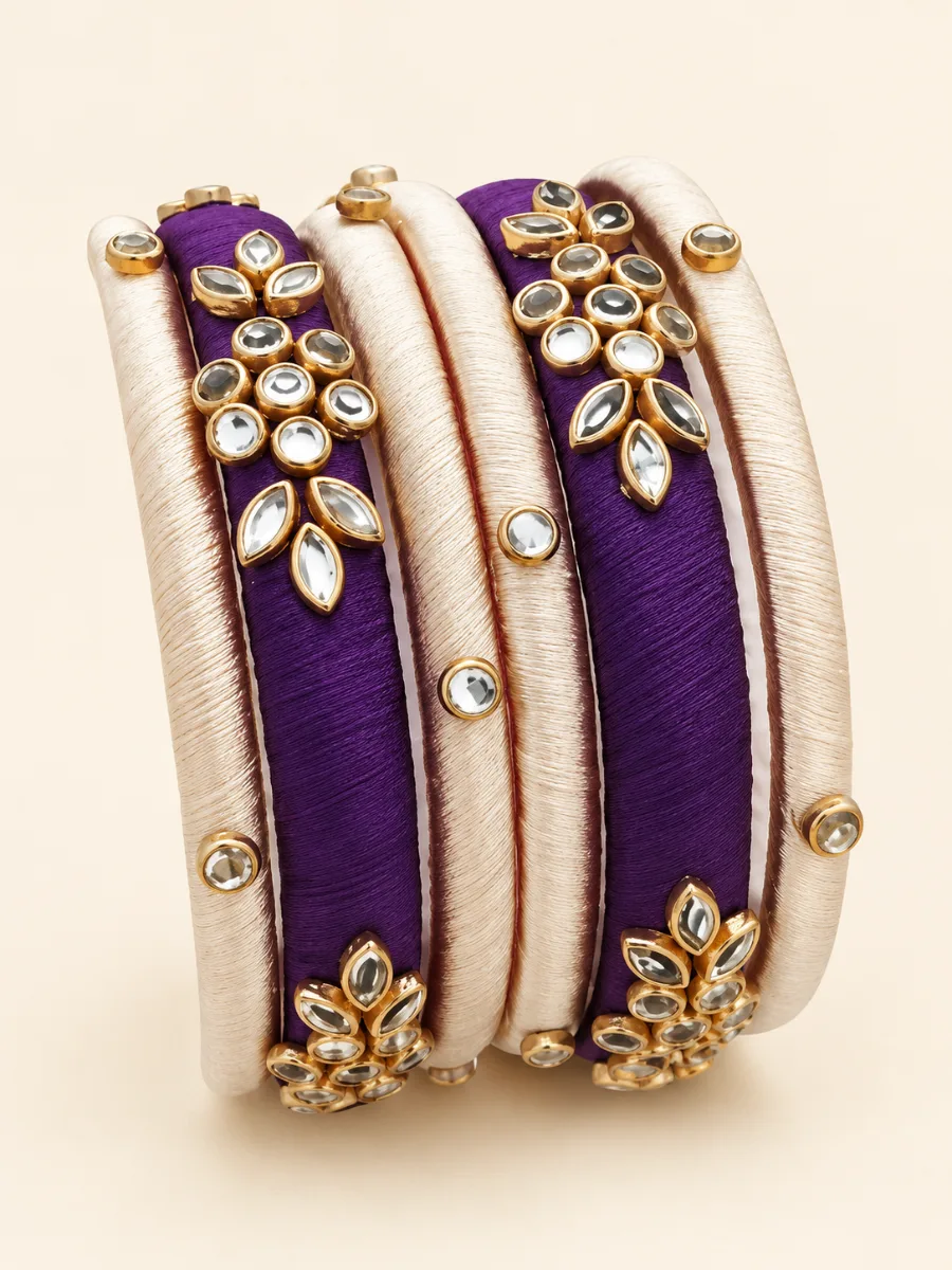 Purple & Ivory Kundan Designer Bangles — Elegant handmade bangles featuring deep purple and ivory thread-wrapped bands with gold-toned kundan-style floral and leaf embellishments.