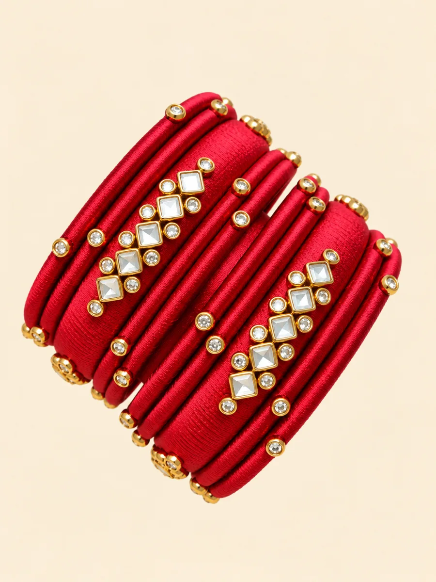 Red Silk Thread Kundan Designer Bangles — Elegant red silk thread bangles featuring gold-toned detailing and sparkling clear Kundan-style square and round stone embellishments.