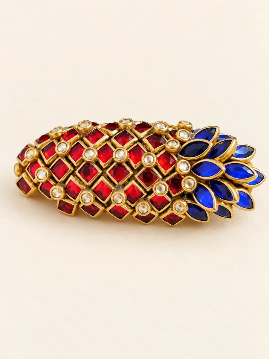 Red & Blue Floral Stone Saree Pin — Handmade saree pin with vibrant red and blue stone embellishments in a traditional floral design.